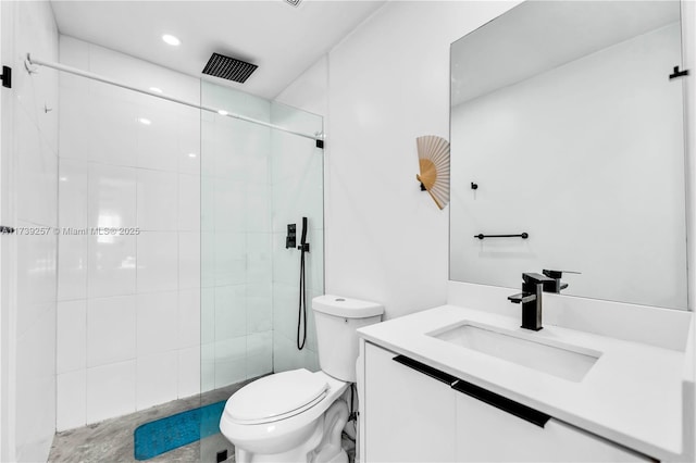 bathroom featuring vanity, a shower with shower door, and toilet