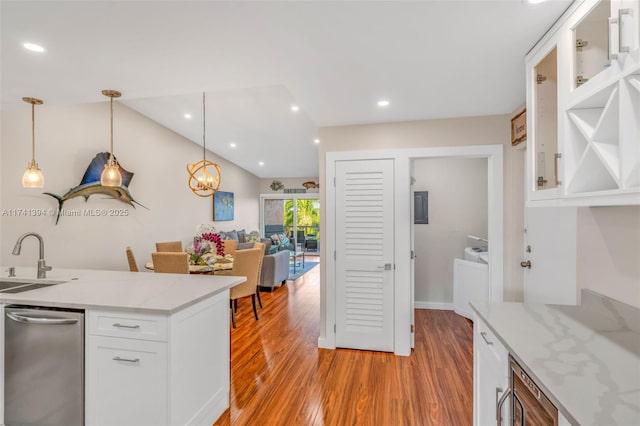 kitchen featuring sink, white cabinetry, light wood-type flooring, pendant lighting, and light stone countertops