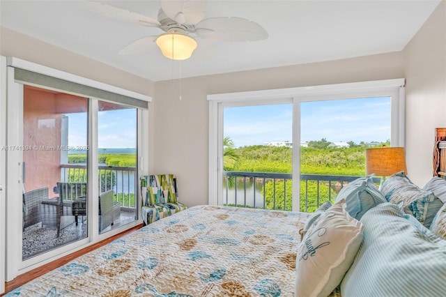 bedroom featuring a water view, ceiling fan, access to exterior, and multiple windows