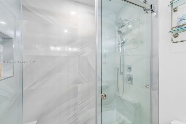 bathroom featuring a shower with shower door