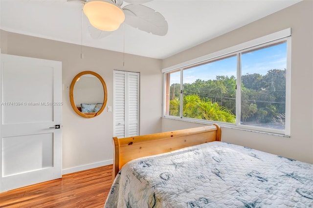 bedroom with ceiling fan, a closet, and light hardwood / wood-style flooring