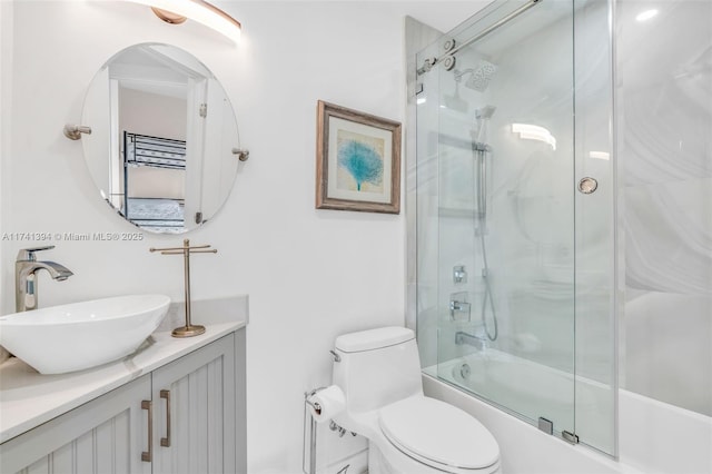 full bathroom featuring enclosed tub / shower combo, vanity, and toilet