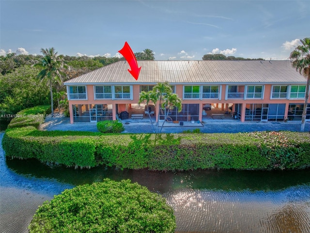 rear view of house featuring a water view and a patio