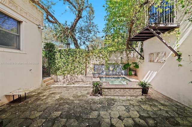 view of patio featuring pool water feature and a jacuzzi