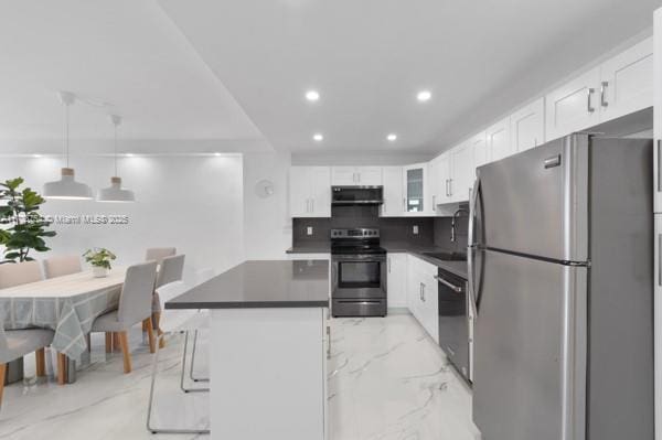 kitchen featuring extractor fan, appliances with stainless steel finishes, decorative light fixtures, sink, and white cabinets