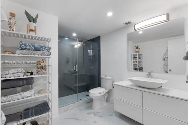 bathroom featuring vanity, toilet, and an enclosed shower