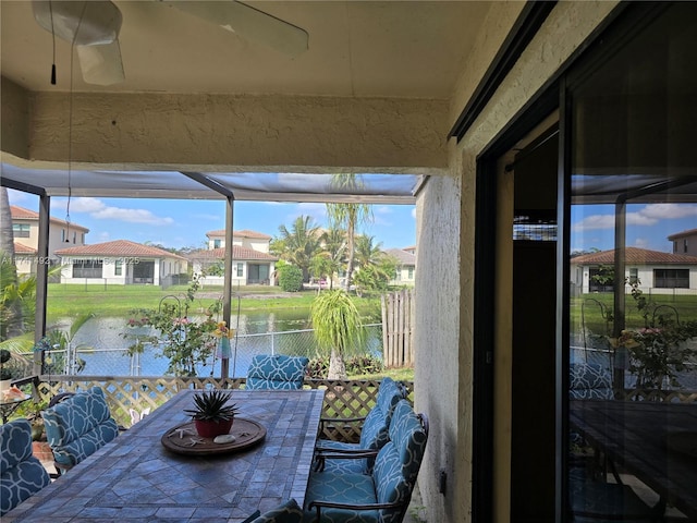 sunroom with a water view and a residential view