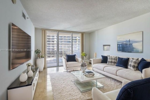 living room featuring expansive windows and a textured ceiling