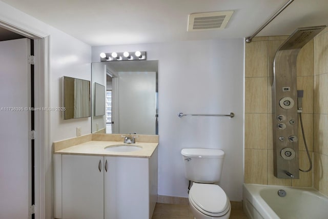 full bathroom with vanity, tiled shower / bath, and toilet