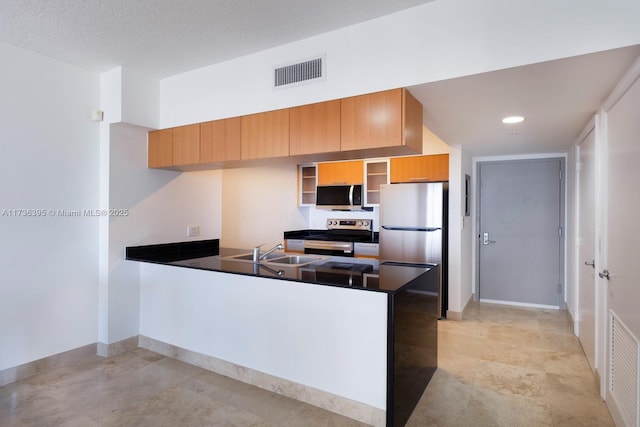 kitchen featuring stainless steel appliances, kitchen peninsula, sink, and a textured ceiling