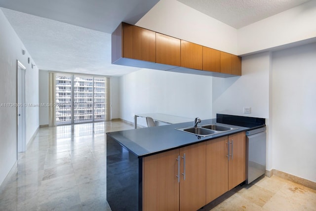 kitchen with expansive windows, dishwasher, sink, and a textured ceiling