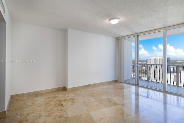 spare room featuring a wall of windows and a textured ceiling