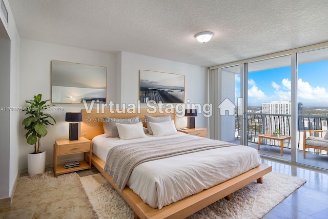 bedroom featuring floor to ceiling windows, access to exterior, and a textured ceiling