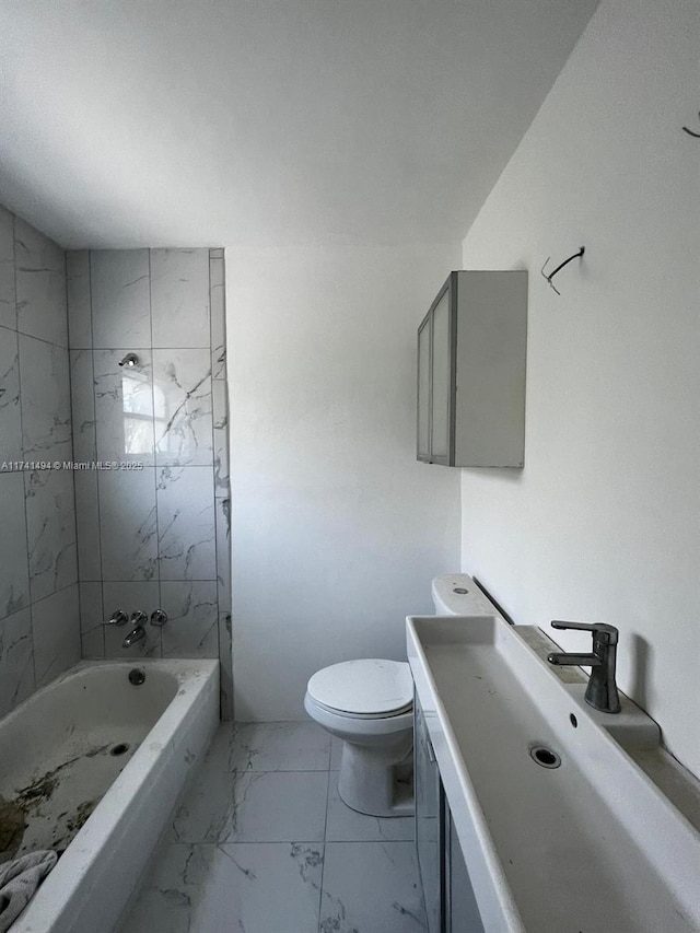 full bathroom featuring tiled shower / bath, vanity, and toilet