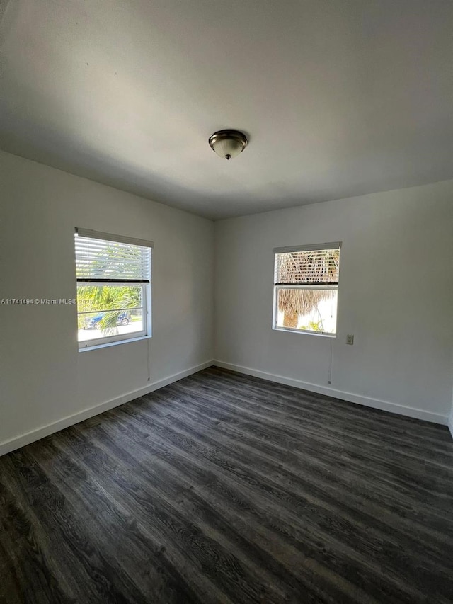 empty room with dark hardwood / wood-style flooring