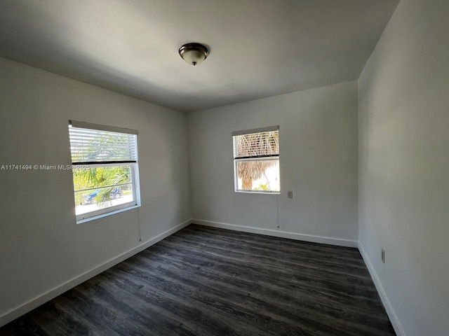 empty room with dark hardwood / wood-style flooring