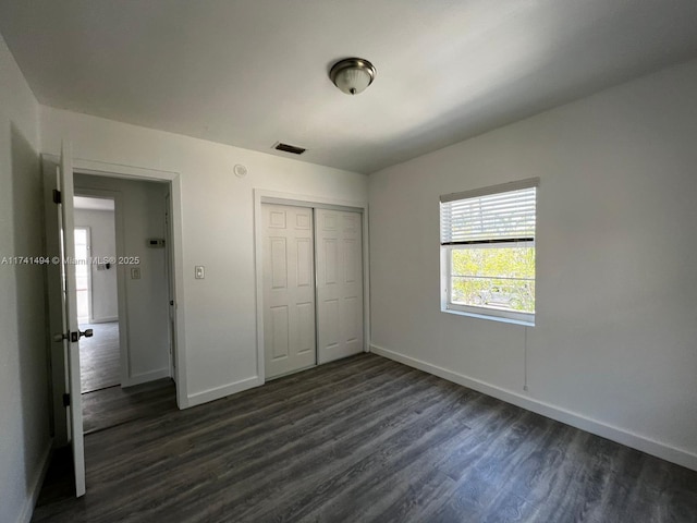 unfurnished bedroom featuring dark hardwood / wood-style flooring and a closet