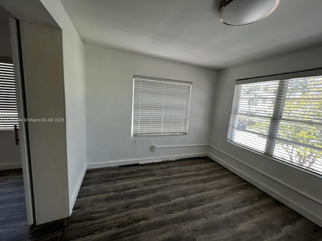 unfurnished room with dark hardwood / wood-style floors