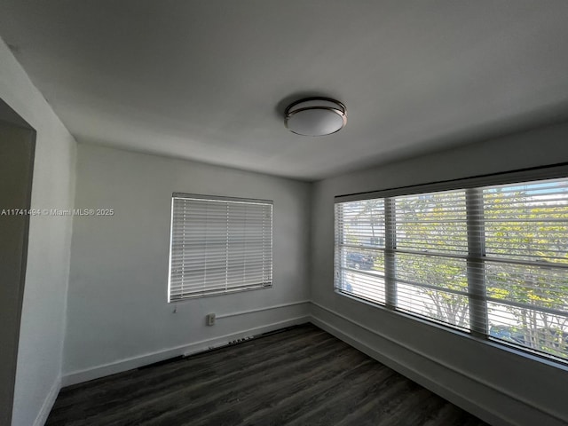 spare room with dark wood-type flooring