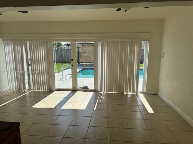 empty room with ceiling fan and dark tile patterned floors