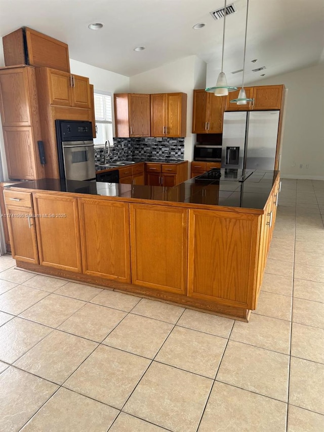 kitchen with pendant lighting, sink, light tile patterned floors, appliances with stainless steel finishes, and backsplash