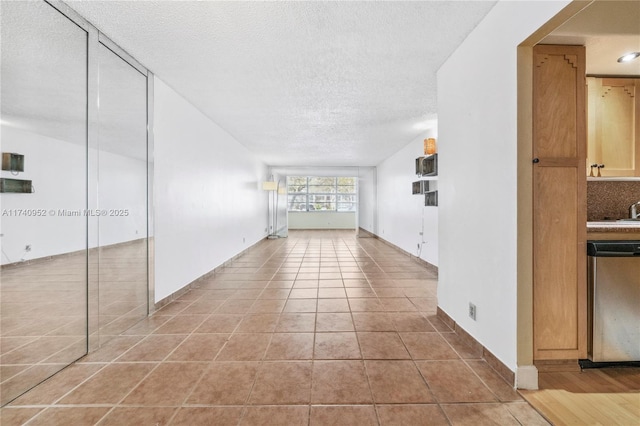 interior space with a textured ceiling and light tile patterned floors