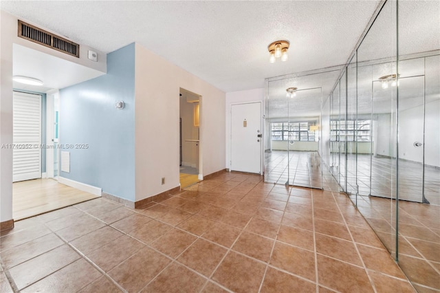 unfurnished room featuring tile patterned floors and a textured ceiling