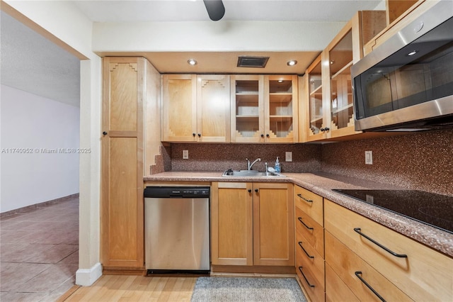 kitchen featuring light brown cabinetry, sink, tasteful backsplash, light stone counters, and appliances with stainless steel finishes