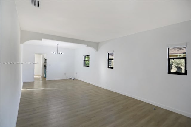 empty room with an inviting chandelier and hardwood / wood-style floors