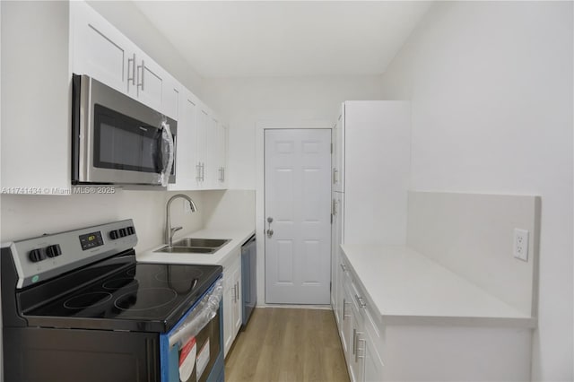 kitchen featuring white cabinetry, appliances with stainless steel finishes, sink, and light hardwood / wood-style floors