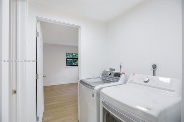 laundry room with light hardwood / wood-style flooring and independent washer and dryer