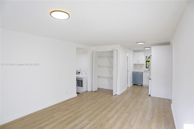 unfurnished living room with washing machine and dryer and light wood-type flooring