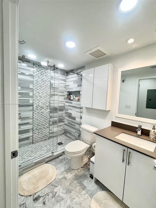 bathroom with vanity, toilet, and a shower with shower door