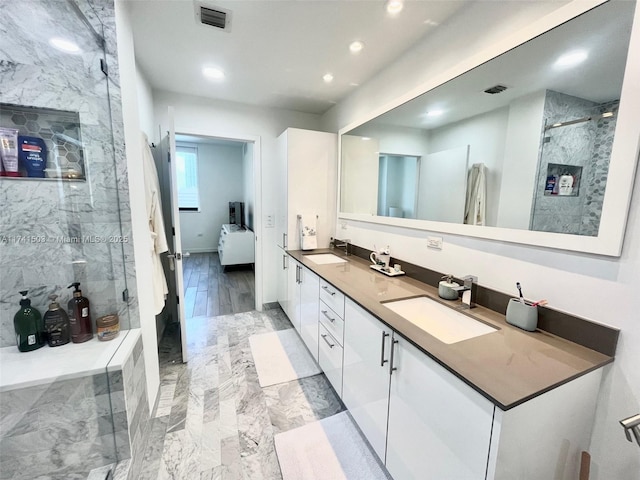 bathroom featuring vanity and a shower with door