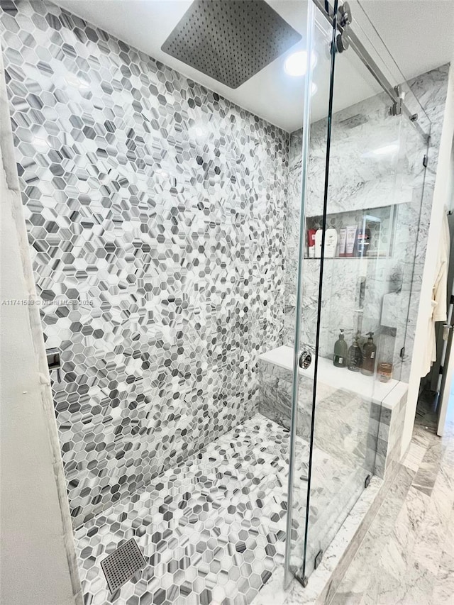 bathroom with a shower with door