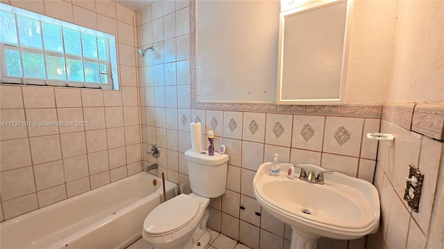 full bathroom with tiled shower / bath combo, sink, tile walls, and toilet