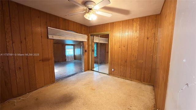 empty room with wooden walls and ceiling fan