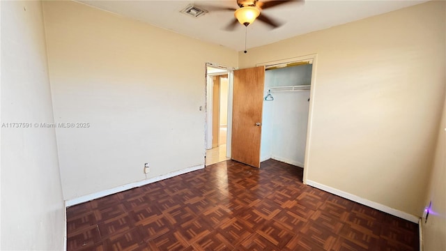 unfurnished bedroom with ceiling fan, a closet, and dark parquet floors