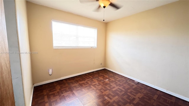 unfurnished room with ceiling fan and dark parquet floors