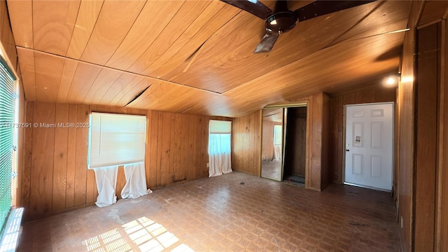 interior space featuring lofted ceiling, wooden ceiling, and wood walls