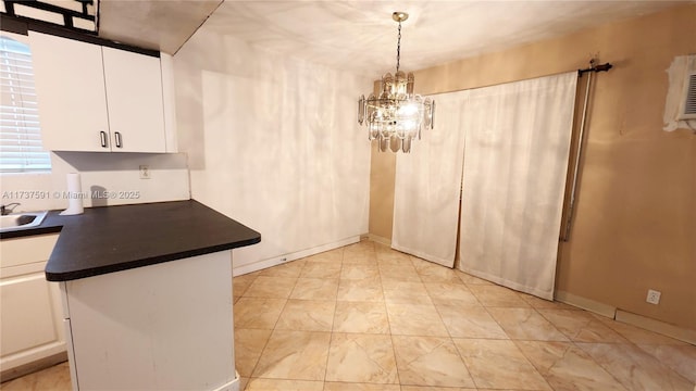 kitchen with white cabinetry, decorative light fixtures, a chandelier, and sink