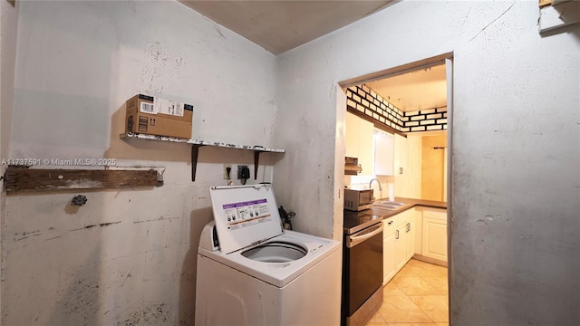 kitchen with washer / clothes dryer, light tile patterned flooring, and sink