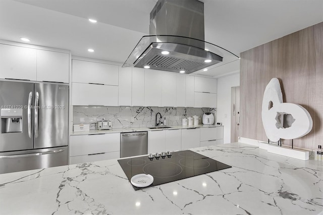 kitchen featuring white cabinets, appliances with stainless steel finishes, light stone countertops, and island range hood