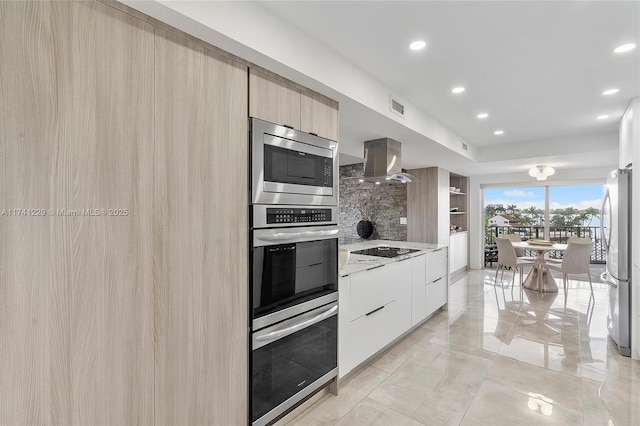 kitchen featuring ventilation hood, light brown cabinets, stainless steel appliances, light stone countertops, and white cabinets