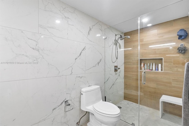 bathroom with toilet, tile walls, and a shower with shower door