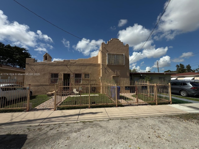 view of front of home featuring a fenced front yard, a gate, and stucco siding