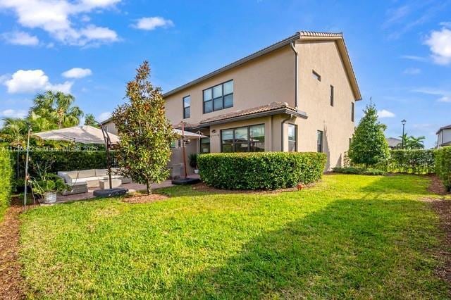 back of house featuring an outdoor hangout area and a lawn