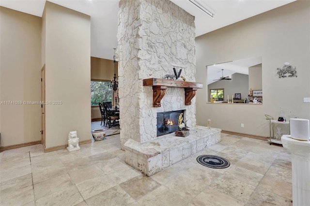 living room with a fireplace, plenty of natural light, high vaulted ceiling, and ceiling fan