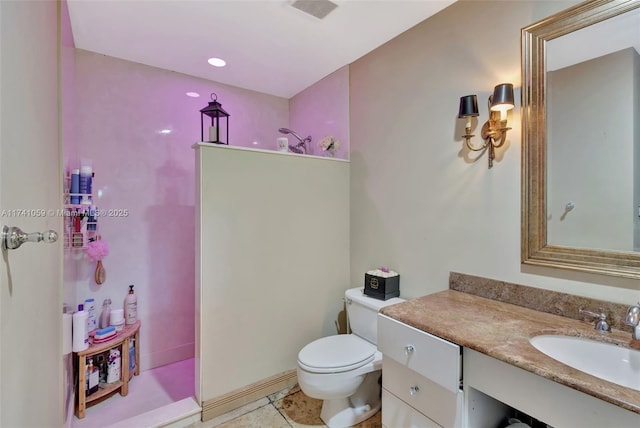 bathroom with toilet, vanity, and walk in shower