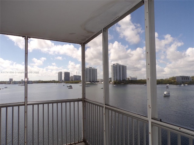 unfurnished sunroom featuring a water view